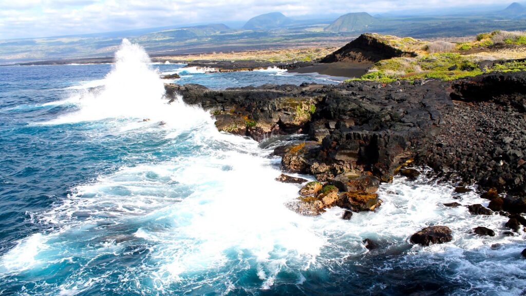 The rough black lava rocks on the Ka'u coastline. Where the Pacific Ocean meets the land.